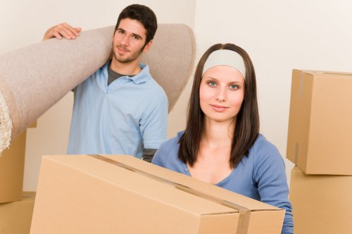 Professional movers carrying furniture through a Maida Hill property