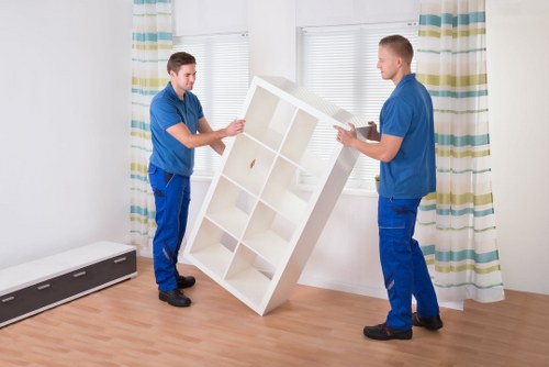 Professional movers handling items in a Maida Hill apartment block